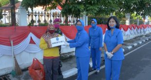 Foto Ketua Jalasenastri Lantamal IV daat membagikan drmbako kepada pekerja menyapu jalan